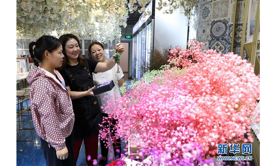 8月19日，在石家庄市桥西区李虹经营的花店内，工作人员在给顾客介绍“永生花”创意产品。 新华社记者 赵丹惠 摄