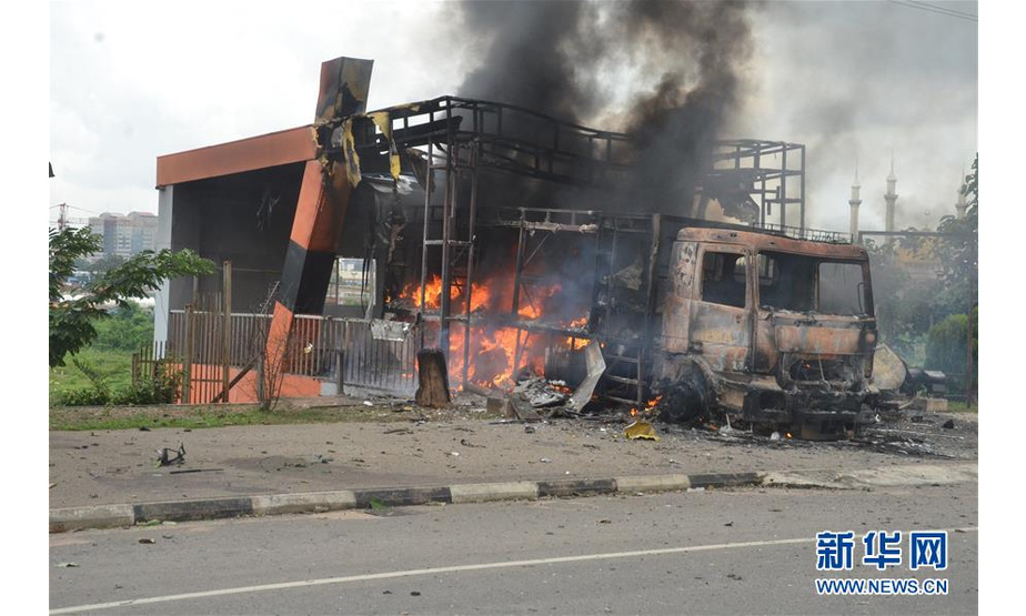 7月22日，在尼日利亚首都阿布贾，车辆在示威中被烧毁。新华社发（奥巴萨摄）