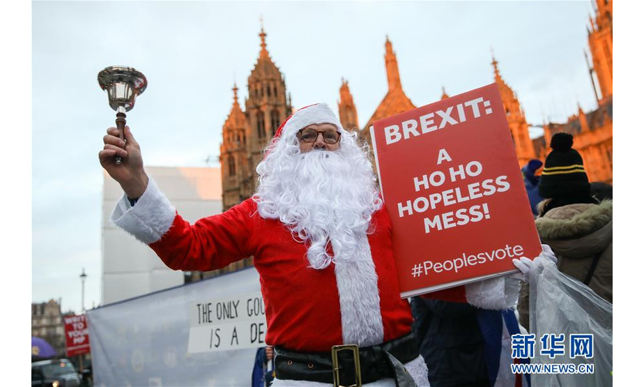 这是12月10日在英国伦敦议会大厦外拍摄的一名装扮成圣诞老人的示威者。  新华社发（乔·纽曼摄）