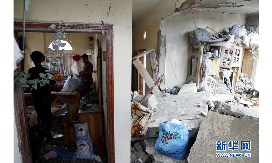 5月16日，在也门首都萨那，当地居民收拾遭空袭的房屋。 也门胡塞武装16日说，沙特阿拉伯领导的多国联军当天对也门首都萨那实施密集空袭，造成至少6名平民死亡。 新华社发（穆罕默德 摄）