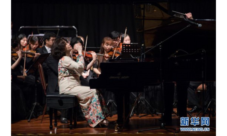7月16日，在马来西亚吉隆坡，马来西亚华人钢琴家克劳迪娅·杨（前）与广西交响乐团在音乐会上表演。 “海丝传琴”庆祝马中建交45周年音乐会16日晚在马来西亚首都吉隆坡上演，来自中国和马来西亚的音乐家们共同呈现了一场中西合璧的交响盛宴。 新华社记者 朱炜 摄