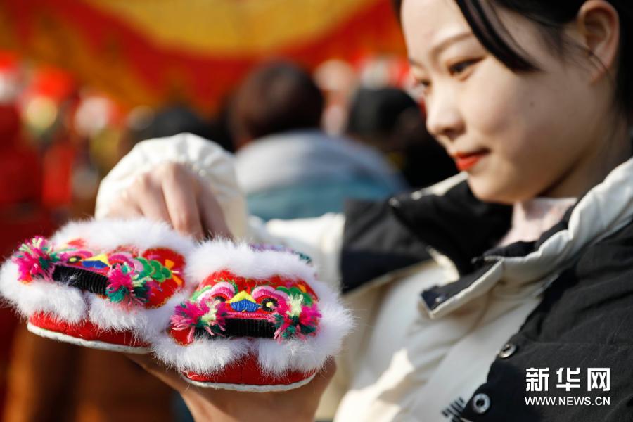 12月27日，在河南省平顶山市宝丰县张八桥镇姚店铺村，游客在观赏虎头鞋。新华社发（何五昌 摄）