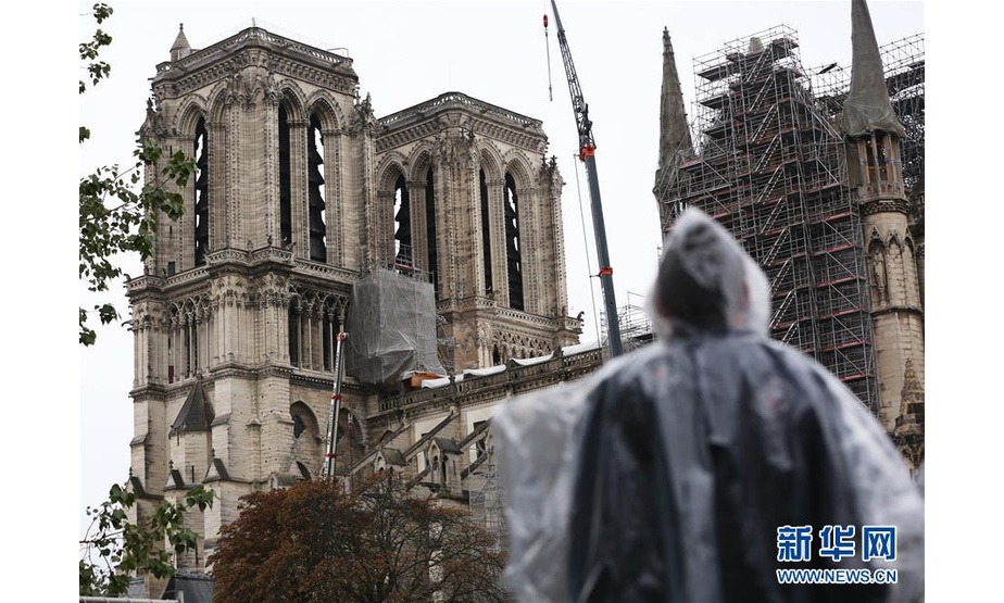 10月17日,在法国巴黎，游客冒雨眺望修缮中的巴黎圣母院。 据法国媒体15日报道，2016年企图袭击巴黎圣母院的5名涉恐人员14日被判处5年至30年徒刑。法国新闻广播电台报道说，5名涉恐人员均为女性，年龄为22岁至42岁，她们在2016年9月企图点燃一辆装载天然气罐的汽车，对法国著名景点巴黎圣母院发动袭击。警方最终挫败其恐怖袭击阴谋。 新华社记者高静摄
