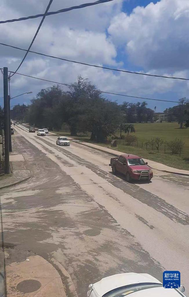 1月20日，在汤加首都努库阿洛法，车辆在铺满火山灰的道路上行驶。努库阿洛法19日开始恢复部分供电和通信。新华社发（Broadcasting Broadcom FM Tonga供图）