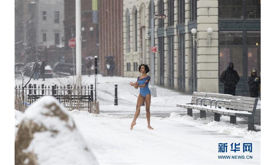 2月20日，在美国纽约布鲁克林大桥附近的商业区，一名女孩在雪中拍照。

　　当日，纽约迎来降雪天气。

　　新华社记者 王迎 摄