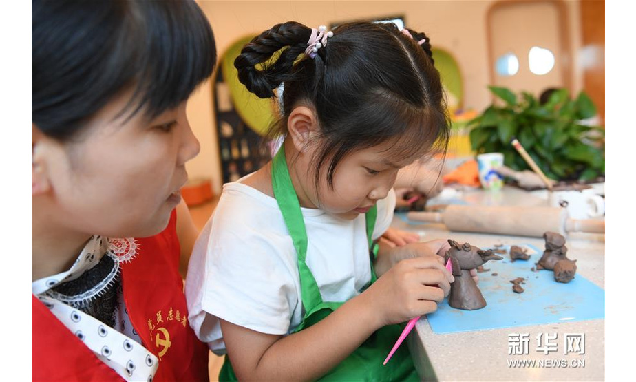 8月19日，新登镇党员志愿者带着小朋友进行陶艺创作。新华社记者翁忻旸摄