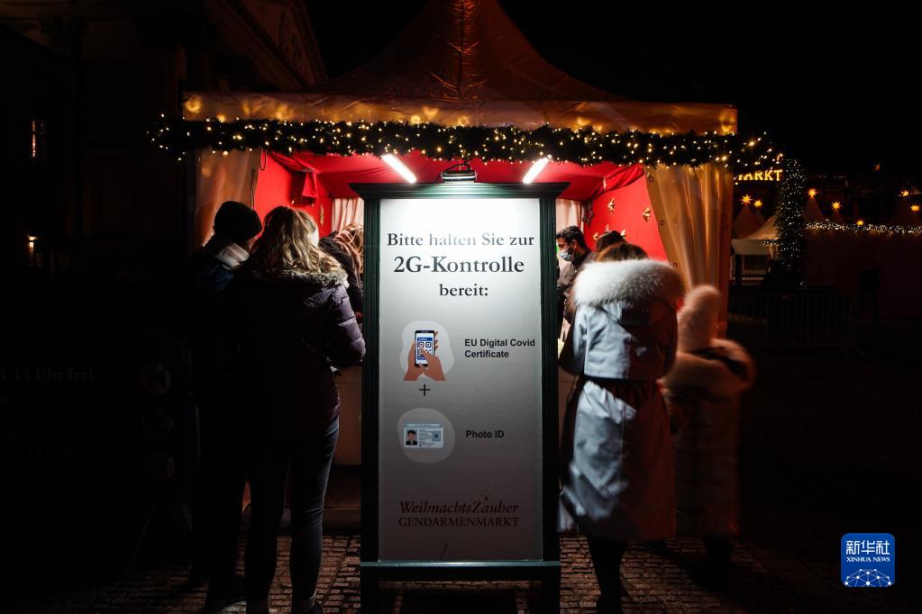 11月22日，在德国首都柏林的宪兵广场，人们在圣诞市场的入口接受新冠疫苗证明或康复证明的检查。

　　受新冠疫情影响，德国柏林、法兰克福等地的圣诞市场有的取消，有的在较为严格的防疫措施下开放。

　　新华社发（斯特凡·蔡茨摄）