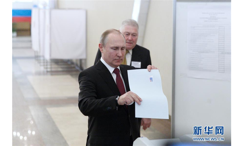 3月18日，俄罗斯总统普京（前）在首都莫斯科一处投票站投票。俄罗斯18日举行总统选举，包括现任总统普京在内的8名总统候选人参选。新华社记者 白雪骐 摄