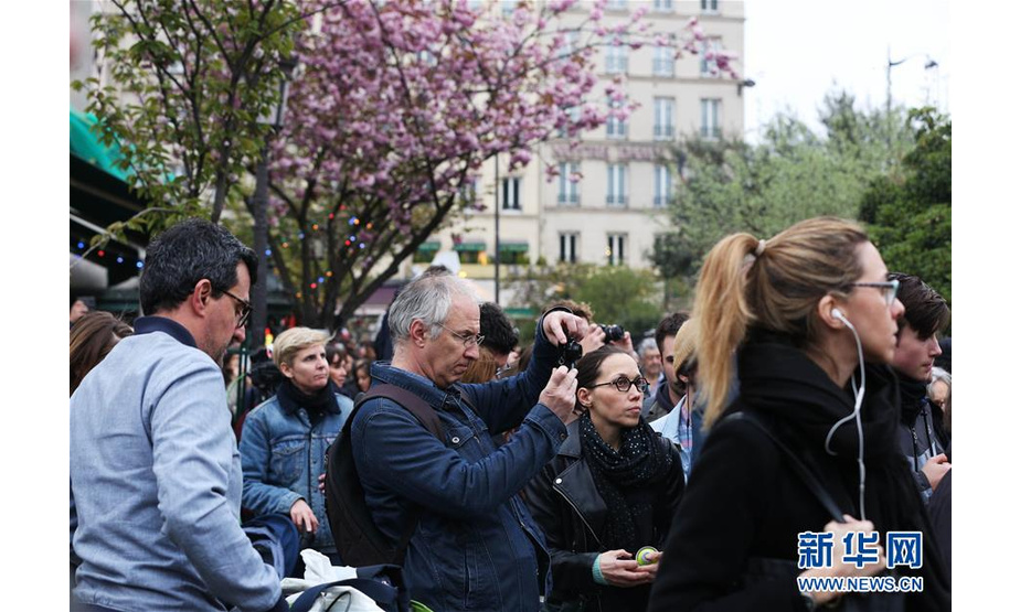 4月16日，在法国巴黎，人们聚集在“受伤”的巴黎圣母院附近。新华社记者 高静 摄