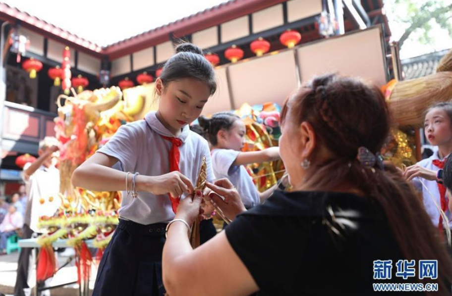 9月11日，非遗项目草把龙传承人在教一名小学生做草把龙。 当日，欢歌庆丰收⋅巴渝月正圆——“我们的节日⋅中秋”活动在重庆市北碚区金刀峡镇举行，活动现场开展了系列传统文化闹中秋活动。 新华社发（黄伟摄）