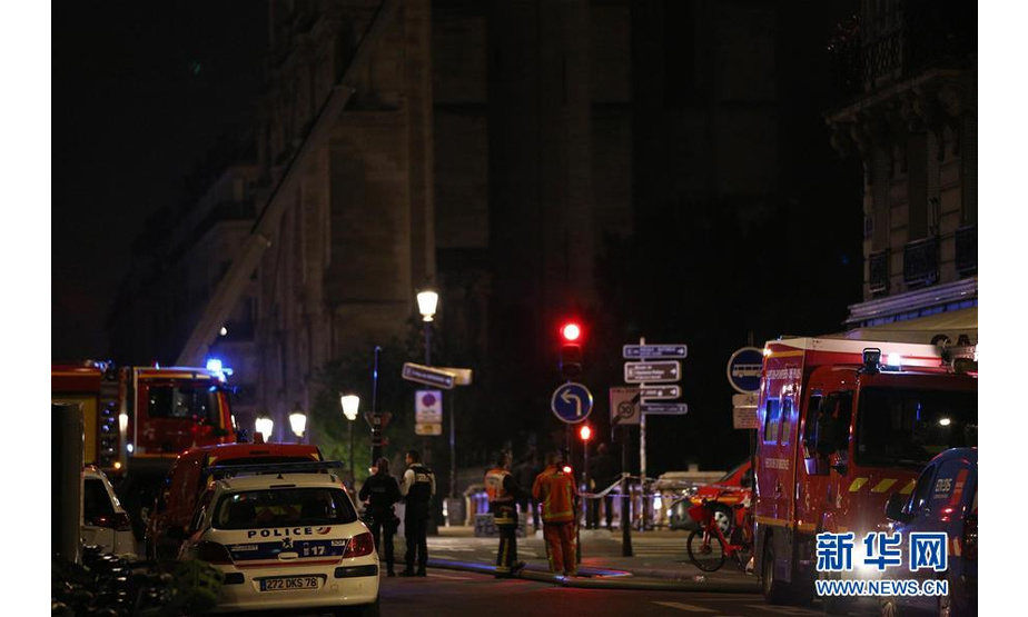 4月15日，在法国巴黎，警车和消防车停靠在巴黎圣母院旁。新华社记者 高静 摄