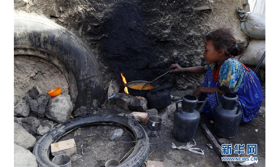 7月22日，在也门萨那郊区一座流离失所者居住的营地内，一名女孩在做早饭。 据联合国数据表明，也门内战爆发四年多来已迫使约330万人流离失所，也门人口的80%、即超过2400万人需要人道主义援助，其中约1000万人面临严重食品短缺。 新华社发（穆罕默德 摄）