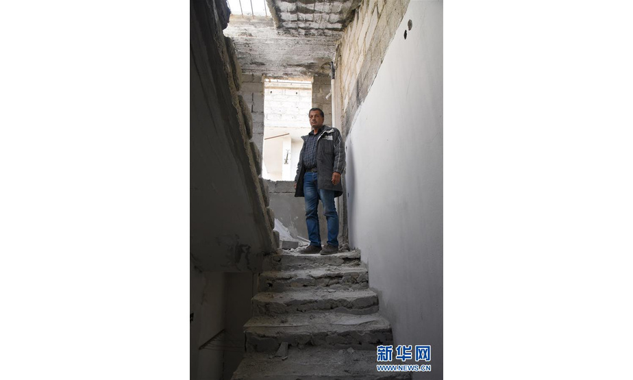 3月12日，在叙利亚大马士革东古塔地区，当地居民萨米尔·加巴里站在整修中的楼梯上。 新华社发（胡马姆·谢赫·阿里 摄）