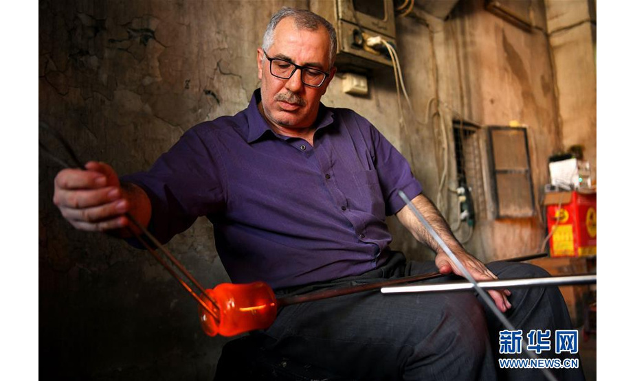 5月27日，在叙利亚大马士革，工匠穆罕默德·哈拉克在制作玻璃制品。新华社发（阿马尔摄）