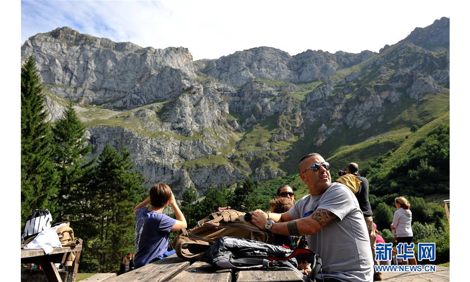 8月21日，游客在西班牙欧洲之峰国家公园内休息。 欧洲之峰位于西班牙北部，是西班牙认定的第一个国家公园。这里气候湿润，植被茂盛，层峦叠嶂，景色十分壮观。每年夏天，都有大量游客前来亲近大自然，享受山中的美景和清凉。 新华社记者 郭求达 摄