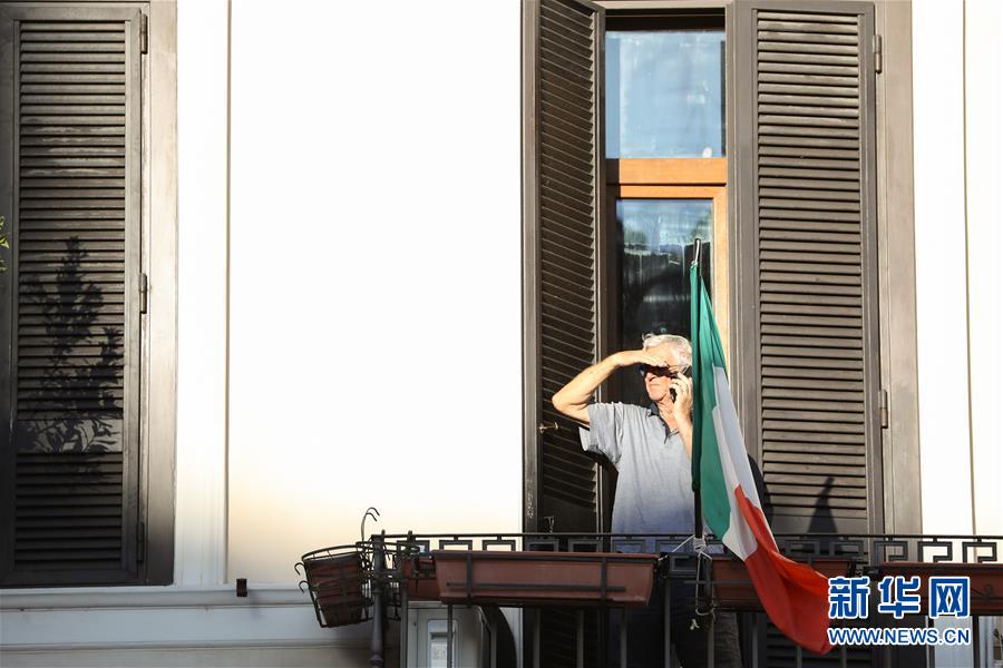 8月4日，在意大利首都罗马，一名男子在阳台打电话。 受新冠疫情影响，今年夏天罗马的历史中心区游客比往年明显减少。 新华社记者 程婷婷 摄