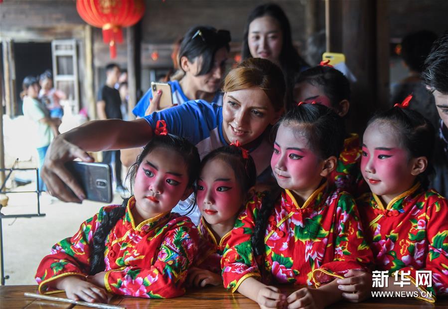 9月11日，来自亚美尼亚的扎娜（左上）与小浦镇当地幼儿园“小京迷”表演队的孩子们合影。 新华社记者 徐昱 摄