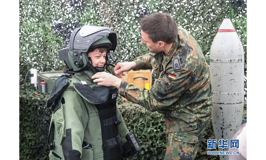 8月18日，在德国首都柏林，一名男孩试穿军事装备。新华社记者 单宇琦 摄