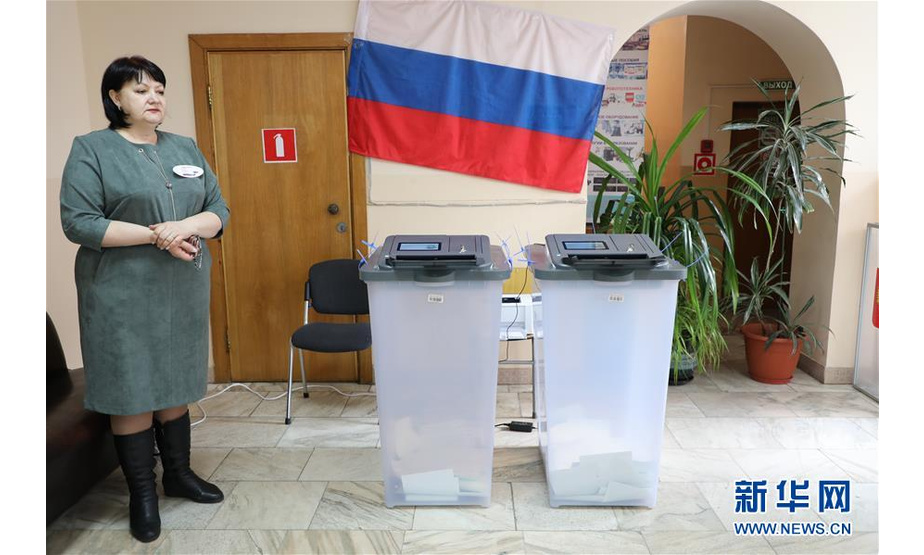 3月18日，在俄罗斯符拉迪沃斯托克的第906号投票站，一名监票人员站在电子投票箱旁。位于俄罗斯领土最东端的堪察加边疆区、楚科奇自治区等地的投票站当地时间18日8时开始开放，2018年俄总统选举投票正式开始。新华社发（丹尼斯摄）