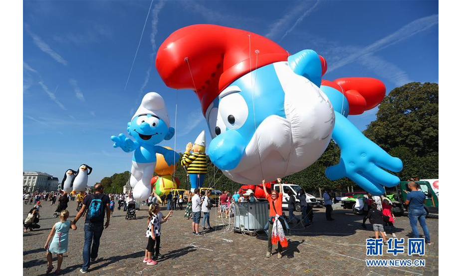 9月15日，人们在比利时首都布鲁塞尔观看卡通气球大巡游。 当日，布鲁塞尔举行第十届布鲁塞尔漫画节卡通气球大巡游，形态各异的卡通气球从街头巷尾穿行而过，吸引大批市民和游客。 新华社记者 郑焕松 摄