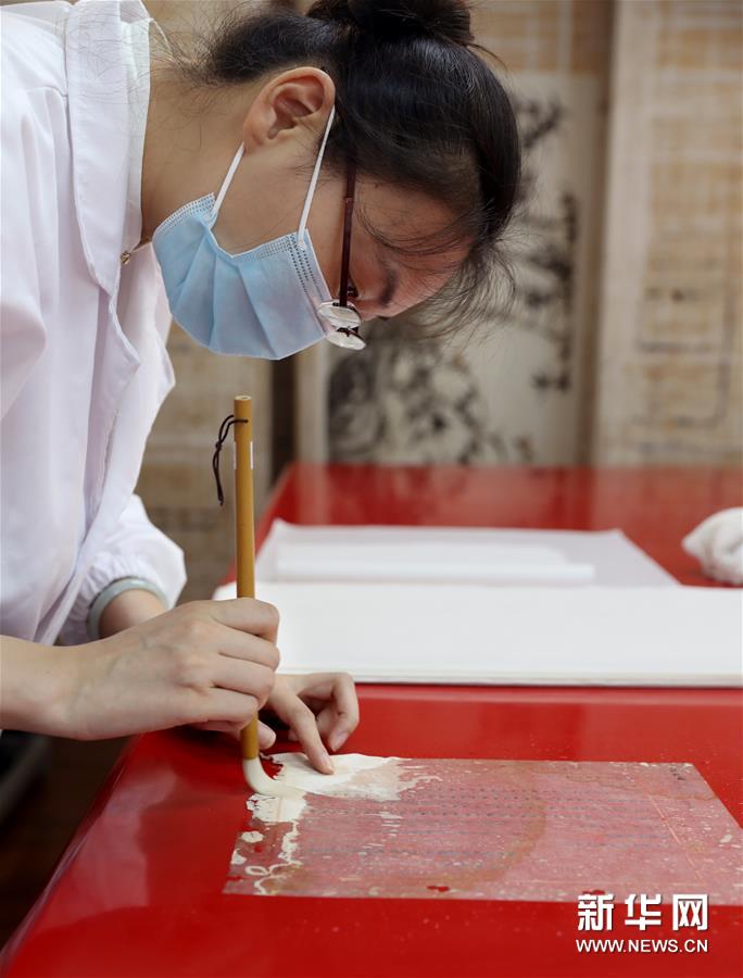 6月29日，上海市档案馆保护技术部的文献修复师孟烨在加固修复档案。新华社记者 刘颖 摄