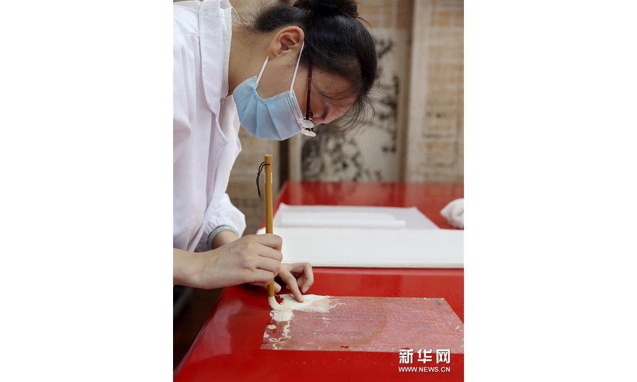 6月29日，上海市档案馆保护技术部的文献修复师孟烨在加固修复档案。新华社记者 刘颖 摄