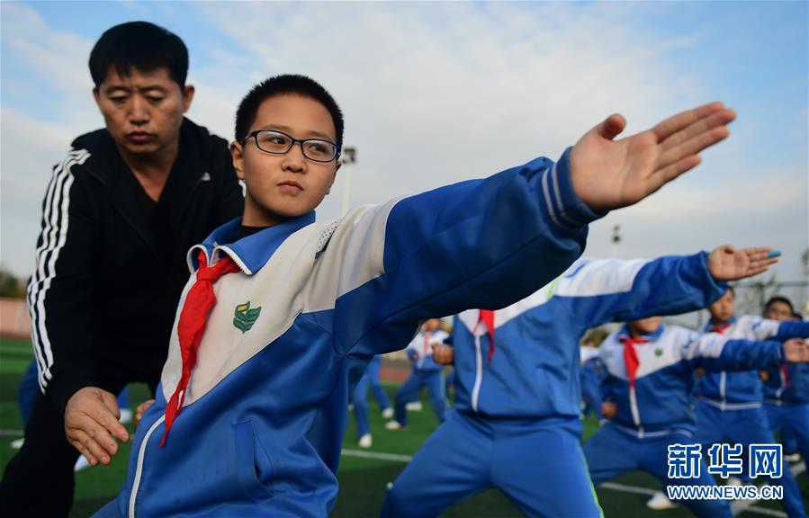 11月19日，沧州青县实验小学的学生在体育老师的指导下练习盘古王拳。 近年来，“武术之乡”河北省沧州市教育、体育部门对体育教师进行强化培训和技术指导，并根据青少年身心特点，编制融合当地特色拳种特点的系列武术教材，持续推进传统武术进校园活动。 新华社记者 王民 摄