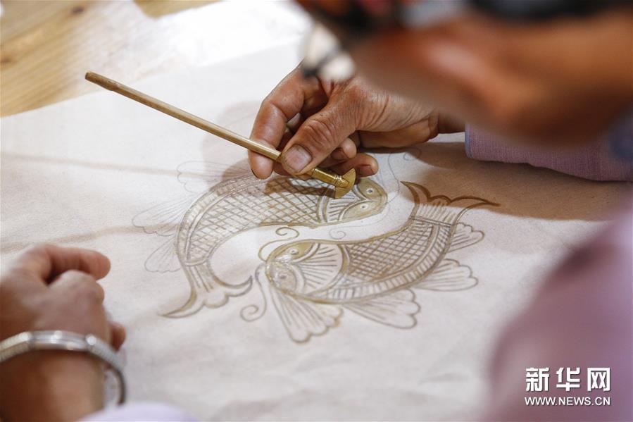 苗族手工艺人在丹寨蜡染合作社内制作蜡染（8月23日摄）。 “‘妈妈制造’使贫困地区的女性完全可以带着娃、绣着花、挣着钱、养着家，实现一种自由的有尊严的生活方式。”中国妇女发展基金会助理秘书长南静介绍。 “妈妈制造”公益项目由中国妇女基金会联合北京蚂蚁力量于2016年共同发起，希望通过对中华传统非遗手工艺的梳理，联合设计师共同创作具有东方文化符号、又符合国际化审美的文创产品，再交给具备一定生产技能的低收入女性制作，使这些女性通过劳动获得报酬、改善生活，从一定程度上解决空巢老人和留守儿童问题。 该项目启动至今将近三年的时间，已经在全国13个省建立了46家“妈妈制造”合作社，直接帮扶了4000多人创业和就业，推动当地的低收入女性居家就业、提高收入。项目通过“妈妈制造”平台的运营，吸引更多年轻人关注传统手工艺，有效促进了传统文化的传承；同时探索将非遗手工艺和现当代艺术相结合的模式，受到了公众的广泛认可：例如在与北京尤伦斯当代艺术中心的合作中，共同创新并发布了以毕加索的艺术风格为灵感、融合中国非遗艺术的手工艺品，包括贵州丹寨蜡染丝巾、贵州台江苗银耳环、江西景德镇骨瓷瓷盘、云南掇花绣抱枕、苗族蜡染笔记本等。 “妈妈制造”通过与知名设计师合作的方式，将小小的非遗手工艺品带出了大山，带着妈妈们的手艺和心意，向世界传播美和温暖。 新华社记者 张玉薇 摄
