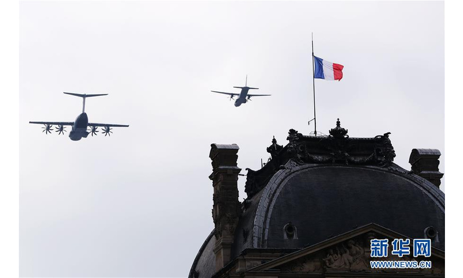7月14日，在法国巴黎举行的国庆阅兵仪式上，法国空军飞机掠过卢浮宫金字塔广场上空。 当日，法国在首都巴黎举行国庆阅兵仪式。 新华社记者 高静 摄