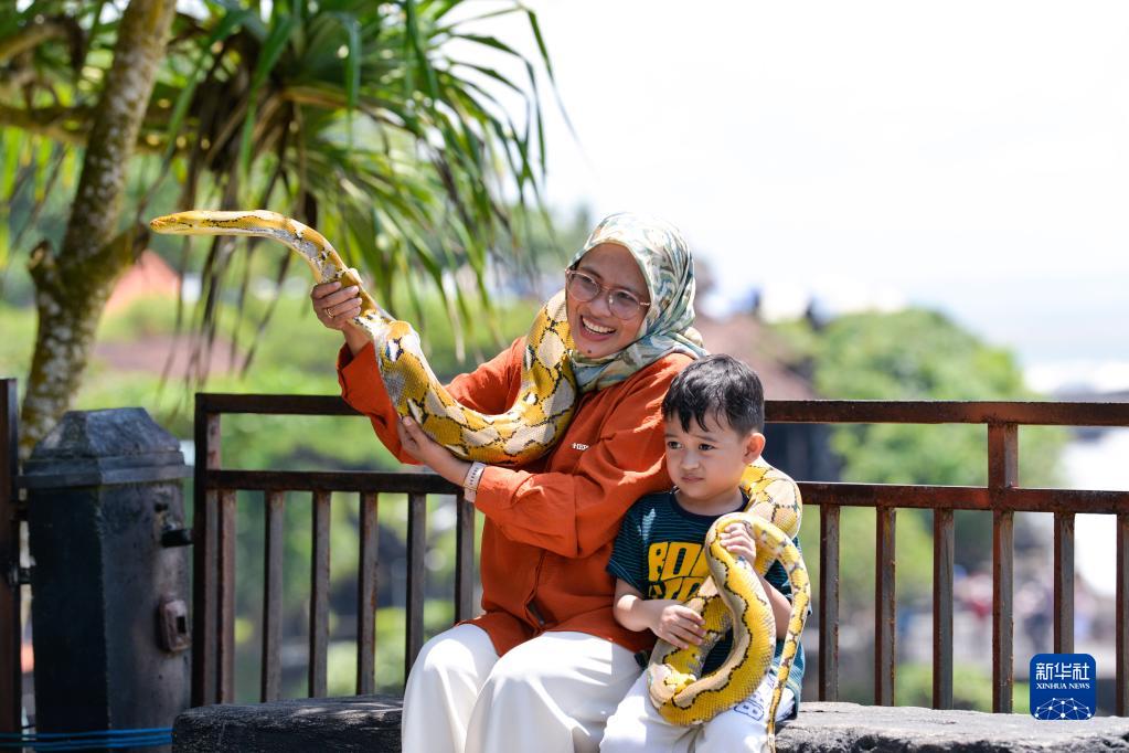 12月18日，在印度尼西亚巴厘岛，游客在海神庙景区留影。

　　印度尼西亚巴厘省统计局数据显示，受新冠疫情影响，今年1月至10月巴厘岛仅接待45名国际游客。不过，随着新年假期临近，印尼国内旅游业显现逐渐恢复的迹象。

　　新华社记者 徐钦 摄