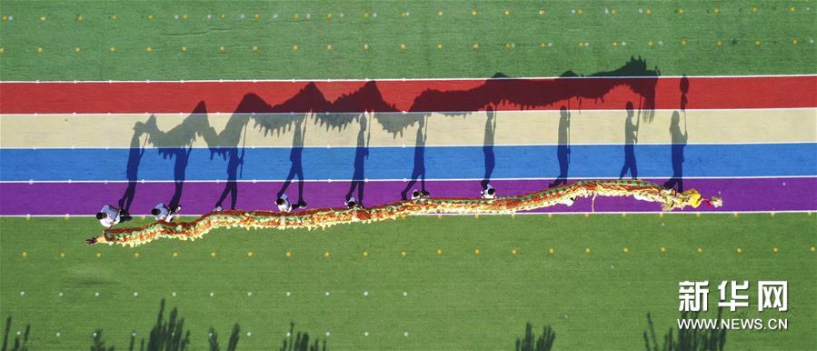 8月4日，孩子们在河北省遵化市平安城镇大麻各庄村校园操场练习民俗节目（无人机照片）。新华社发（刘满仓 摄）