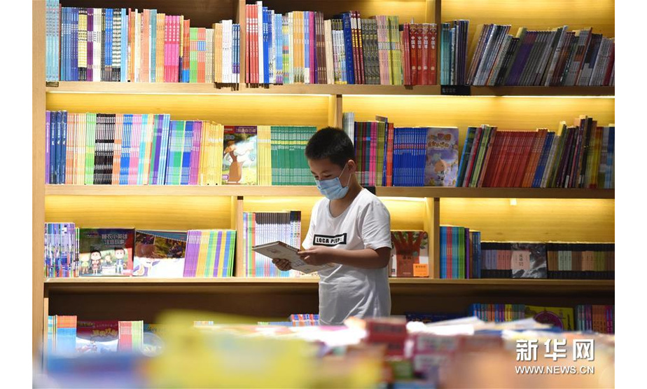 7月5日，一名小朋友在河北省定州市新华书店挑选图书。新华社记者 朱旭东 摄