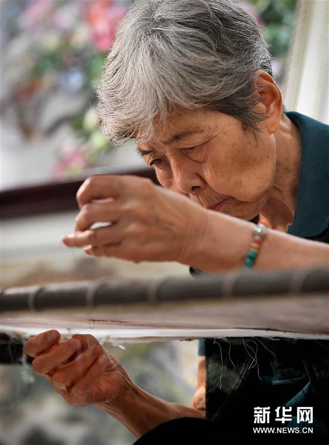 在开封市素花宋绣工艺有限公司的展示馆里，王素花在刺绣（7月30日摄）。新华社记者李安摄