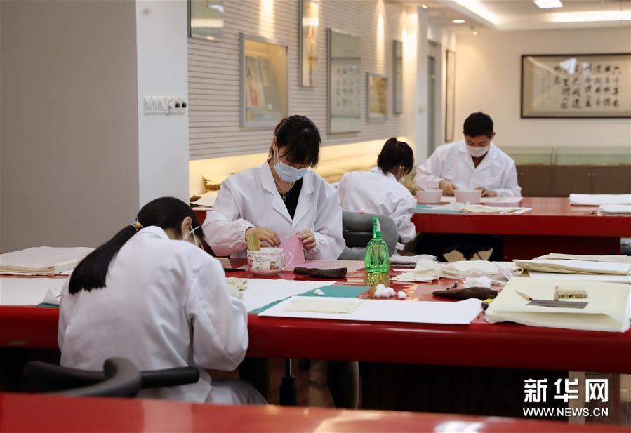 6月29日，上海市档案馆保护技术部的工作人员在修复档案。上海市档案馆馆藏的档案中有一部分是记录着中国共产党发展历程的珍贵档案。为了保存这些经过岁月洗礼的档案，档案工作人员在细心保管的基础上，对一些破损档案开展细致、专业的修复工作，留存历史记忆。新华社记者 刘颖 摄