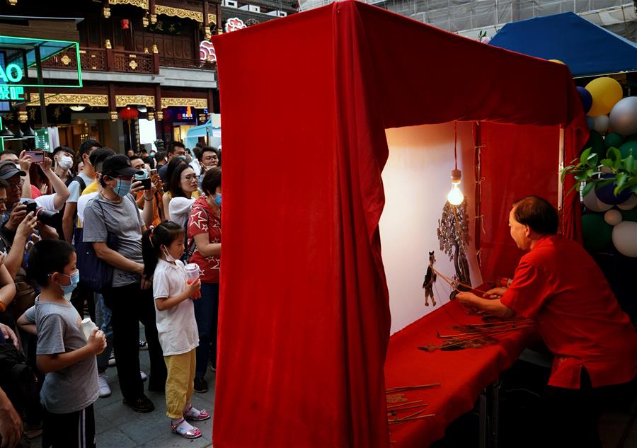 从7月第一个周末起，上海豫园原有的“豫园六点半”集市全面升级，焕彩灯光、演艺活动和花车集市全线更新，让市民和游客在观灯、观人、观演的沉浸式体验中，享受夏日特色的“食玩”乐趣。 新华社记者 刘颖 摄