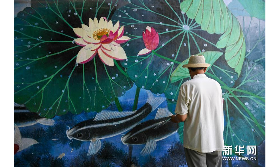 7月18日，吴吉人在吉林市船营区光华路附近一个小区的墙壁上作画。新华社发（颜麟蕴摄）
