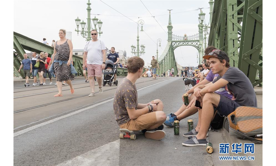 7月21日，人们在匈牙利首都布达佩斯的自由桥上游玩。近日，坐落在多瑙河上的布达佩斯自由桥改为行人专用，车辆不能通过此桥，大桥成为人们观赏沿岸美景休闲怡情的好去处。新华社发（弗尔季·奥蒂洛摄）