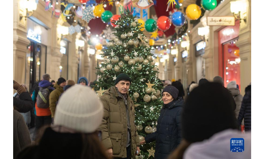 12月11日，在俄罗斯首都莫斯科的古姆百货商场，人们在新年枞树旁留影。

　　新华社记者白雪骐摄