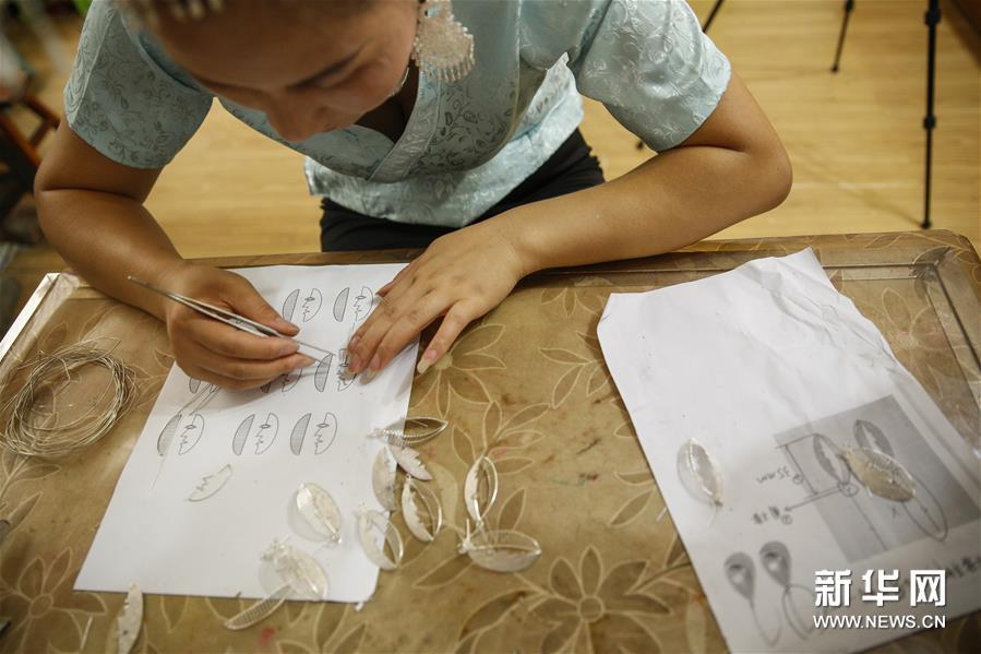 一名苗族手工艺人在贵州台江制作苗银耳环（8月22日摄）。 “‘妈妈制造’使贫困地区的女性完全可以带着娃、绣着花、挣着钱、养着家，实现一种自由的有尊严的生活方式。”中国妇女发展基金会助理秘书长南静介绍。 “妈妈制造”公益项目由中国妇女基金会联合北京蚂蚁力量于2016年共同发起，希望通过对中华传统非遗手工艺的梳理，联合设计师共同创作具有东方文化符号、又符合国际化审美的文创产品，再交给具备一定生产技能的低收入女性制作，使这些女性通过劳动获得报酬、改善生活，从一定程度上解决空巢老人和留守儿童问题。 该项目启动至今将近三年的时间，已经在全国13个省建立了46家“妈妈制造”合作社，直接帮扶了4000多人创业和就业，推动当地的低收入女性居家就业、提高收入。项目通过“妈妈制造”平台的运营，吸引更多年轻人关注传统手工艺，有效促进了传统文化的传承；同时探索将非遗手工艺和现当代艺术相结合的模式，受到了公众的广泛认可：例如在与北京尤伦斯当代艺术中心的合作中，共同创新并发布了以毕加索的艺术风格为灵感、融合中国非遗艺术的手工艺品，包括贵州丹寨蜡染丝巾、贵州台江苗银耳环、江西景德镇骨瓷瓷盘、云南掇花绣抱枕、苗族蜡染笔记本等。 “妈妈制造”通过与知名设计师合作的方式，将小小的非遗手工艺品带出了大山，带着妈妈们的手艺和心意，向世界传播美和温暖。 新华社记者 韩晓雨 摄