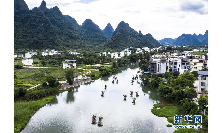 8月2日，在广西桂林市阳朔县，游人乘坐竹筏在遇龙河上游玩（无人机照片）。 新华社发（李斌 摄）