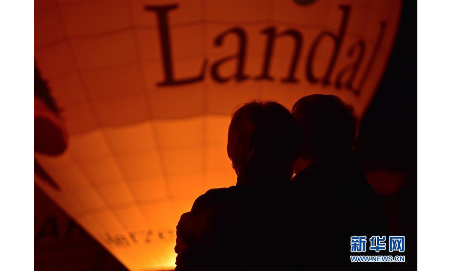 6月8日，在德国波恩，人们在热气球节上观看热气球点火表演。新华社记者 逯阳 摄