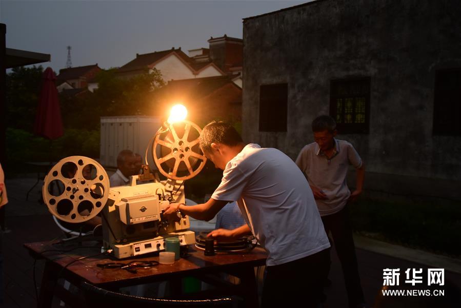 6月30日，朱强在当晚电影开播前调试放映机镜头焦距。新华社记者 郑梦雨 摄