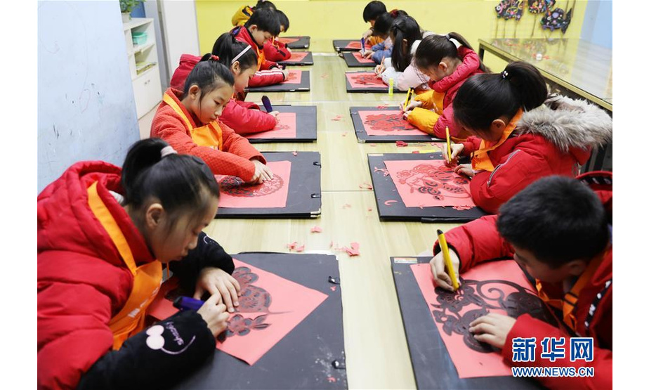 1月19日，孩子们在湖南省永州市道县的一家美术工作室制作用于装饰生肖灯笼的剪纸。 鼠年春节临近，孩子们通过亲手制作生肖主题的灯笼，感受传统民俗文化的魅力。 新华社发（何红福 摄）
