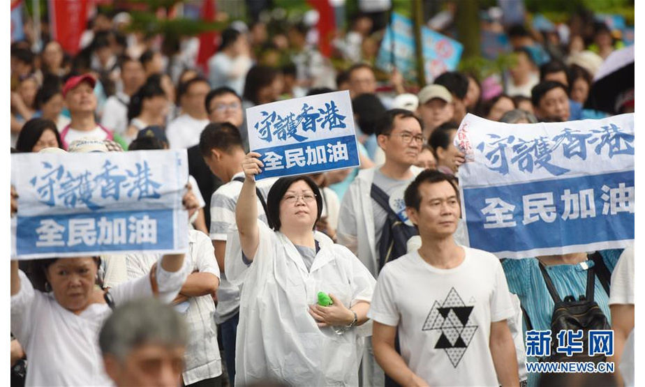 7月20日，在香港添马公园，香港市民举起“守护香港”的标语。新华社记者 王申 摄