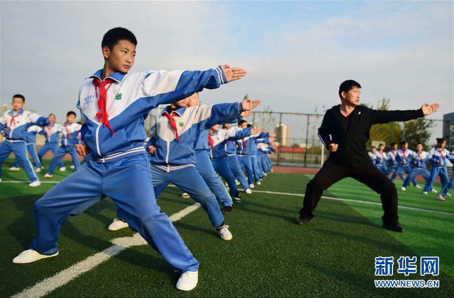 11月19日，沧州青县实验小学的学生在体育老师的指导下练习盘古王拳。 近年来，“武术之乡”河北省沧州市教育、体育部门对体育教师进行强化培训和技术指导，并根据青少年身心特点，编制融合当地特色拳种特点的系列武术教材，持续推进传统武术进校园活动。 新华社记者 王民 摄