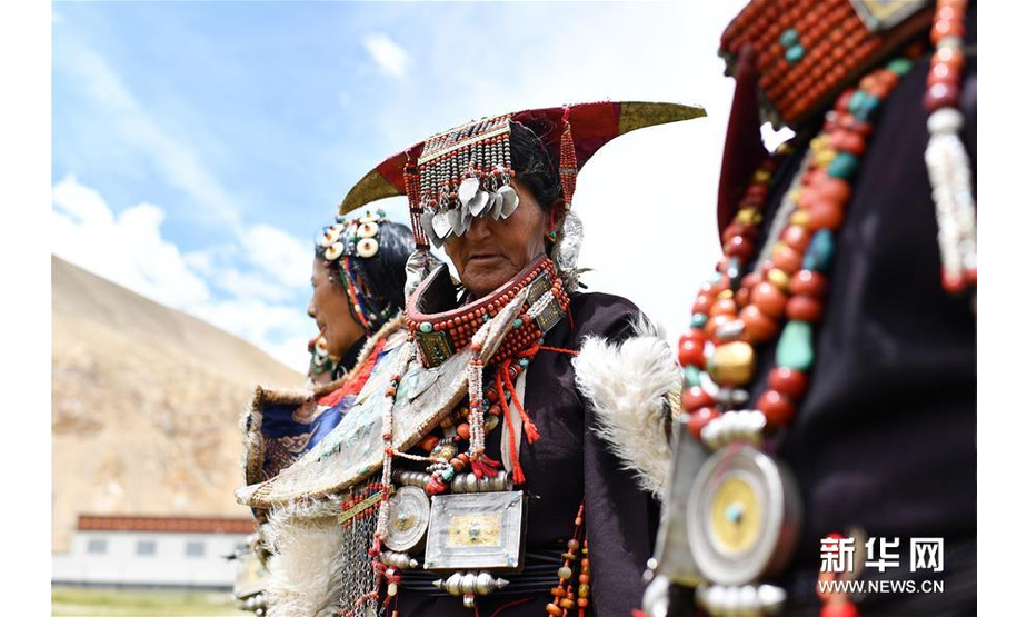 在西藏阿里地区普兰县科迦村，村民在展示普兰服饰（7月28日摄）。在西藏阿里地区普兰县，至今保留着独特的藏族服饰——普兰服饰。据了解，普兰服饰已有1000多年的历史，其中最精美、最独特的是妇女的“孔雀”服饰，一套重达20多公斤，装饰有黄金、白银、蜜蜡、珊瑚、绿松石等，堪称“穿在身上的千年历史”。新华社记者 詹彦 摄