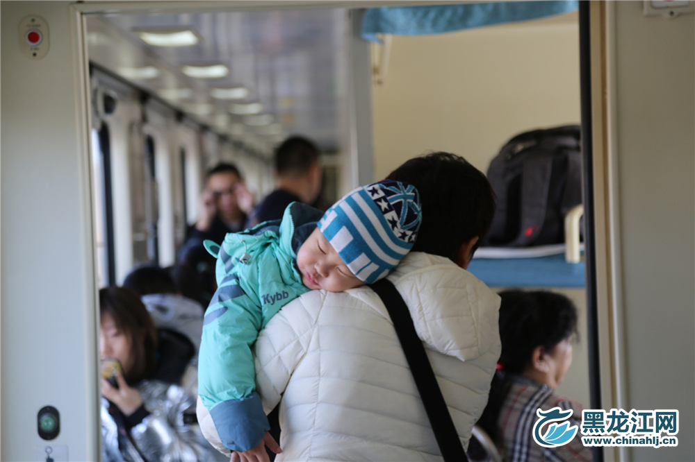 上车后有些疲惫的孩子趴在父亲的肩膀上睡着了。 石启立 摄