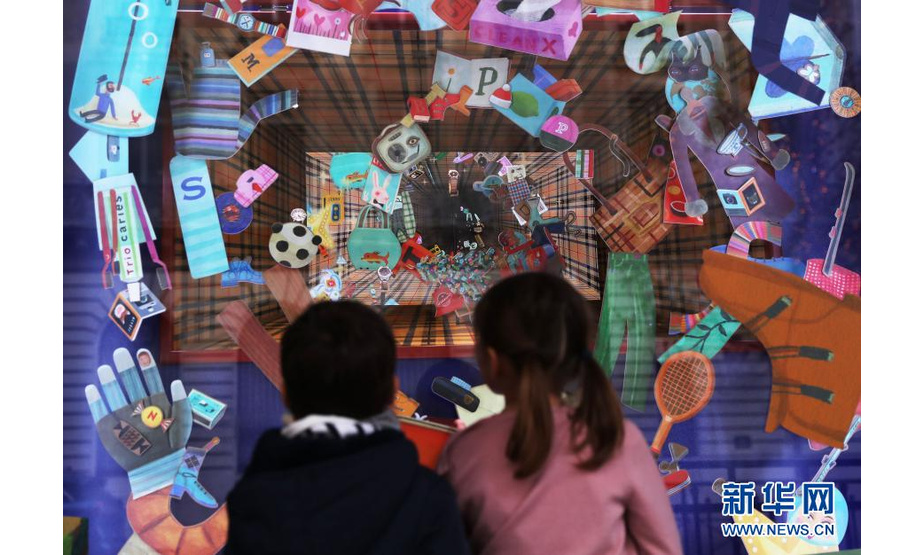 11月22日，孩子们在法国巴黎老佛爷百货商店的圣诞橱窗前驻足欣赏。新华社记者 高静 摄