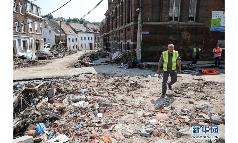 7月20日，一名工作人员在比利时受灾严重的佩平斯特走过受损的街道。

　　比利时危机中心20日证实，上周的暴雨及其引发的特大洪灾已造成31人死亡、70多人失踪，全国100多个市镇受到影响。目前，比利时全国范围内的降雨已停止，洪水也已基本退去，灾后重建工作正在有序展开。

　　新华社记者 张铖 摄