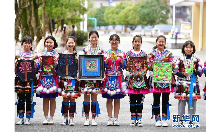 在融水苗族自治县民族中学，女童班的学生在展示刺绣作品（3月22日摄）。  新华社记者 黄孝邦 摄